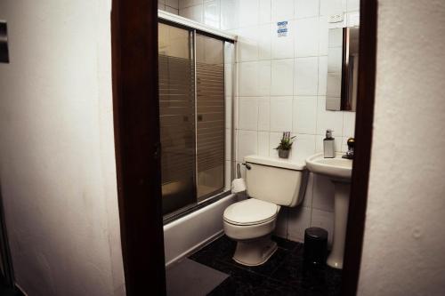 a small bathroom with a toilet and a sink at Residenciales H1 & H2 - Breakfast & Room Service - Airport close in Santiago de los Caballeros