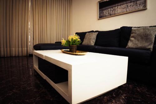 a living room with a couch and a white coffee table at Residenciales H1 & H2 - Breakfast & Room Service - Airport close in Santiago de los Caballeros