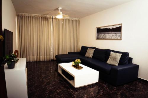 a living room with a couch and a coffee table at Residenciales H1 & H2 - Breakfast & Room Service - Airport close in Santiago de los Caballeros