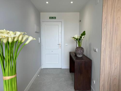 a hallway with a vase of flowers on a table at Apartamento Calas in Noja