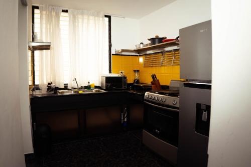 a kitchen with a sink and a stove at Residenciales H1 & H2 - Breakfast & Room Service - Airport close in Santiago de los Caballeros