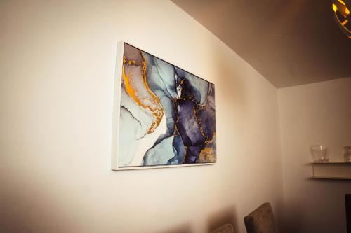 a painting hanging on a wall in a room at Residenciales H1 & H2 - Breakfast & Room Service - Airport close in Santiago de los Caballeros