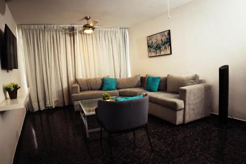 a living room with a couch and a table at Residenciales H1 & H2 - Breakfast & Room Service - Airport close in Santiago de los Caballeros
