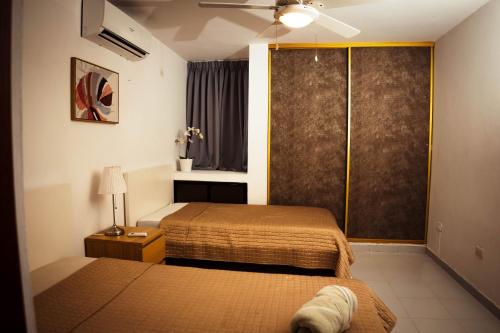 a bedroom with two beds and a sliding glass door at Residenciales H1 & H2 - Breakfast & Room Service - Airport close in Santiago de los Caballeros