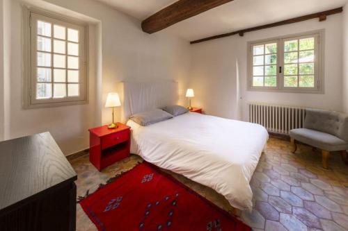 - une chambre avec un lit, une chaise et deux fenêtres dans l'établissement Mas de charme avec piscine, à Antibes