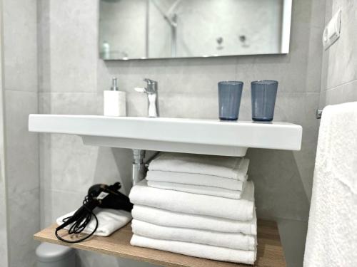 a bathroom with a sink and a pile of towels at Apartamento Calas in Noja