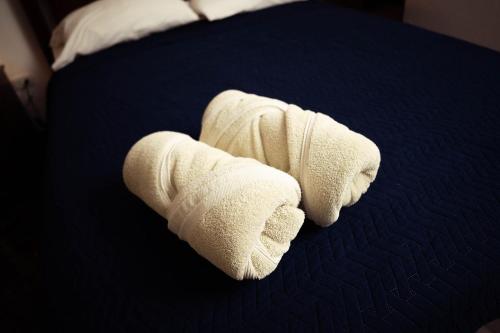 a stack of white towels on a bed at Residenciales H1 & H2 - Breakfast & Room Service - Airport close in Santiago de los Caballeros