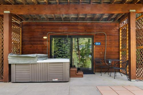 a patio with a grill and a table in front of a door at Bugle Pointe B12 by Estes Park Condos in Estes Park