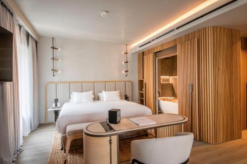 a hotel room with a bed and a table at Only YOU Hotel Málaga in Málaga