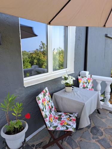 a table and chairs with a table and a window at Garden Rooms in Pírgos Psilonérou