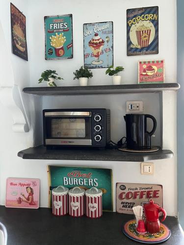 a kitchen counter with a microwave on a shelf at Ambrazzurra Apartament in Aci Castello