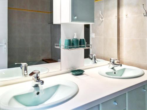 a bathroom with two sinks and a mirror at Appartement d'une chambre avec piscine partagee jardin clos et wifi a Marseillan a 6 km de la plage in Marseillan