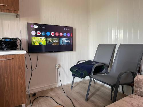 a living room with two chairs and a flat screen tv at Mahane in Tirana