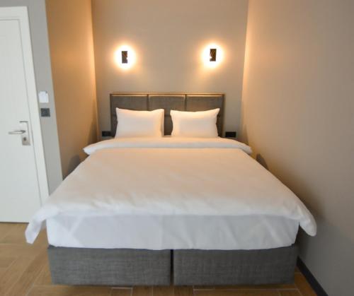 a bed with white sheets and pillows in a room at Ağva Casa Rosa Bungalov Otel in Sile
