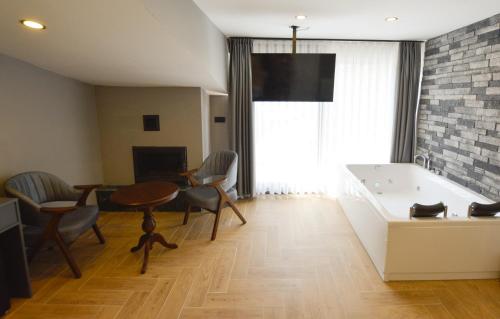 a living room with a table and chairs and a tub at Ağva Casa Rosa Bungalov Otel in Sile