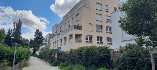 un grand bâtiment avec un trottoir devant lui dans l'établissement Une résidence à 30 minutes du coeur de Paris !, à Romainville