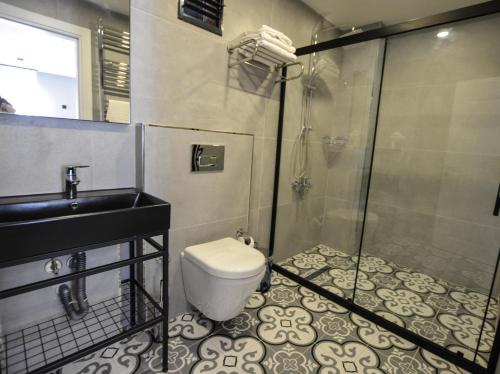 a bathroom with a shower and a toilet and a sink at Ağva Casa Rosa Bungalov Otel in Sile