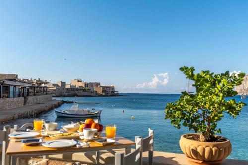 a table with food and a view of the water at Akroyiali - Guesthouse in Gerolimenas