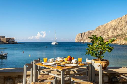 a table with food and a view of the ocean at Akroyiali - Guesthouse in Gerolimenas