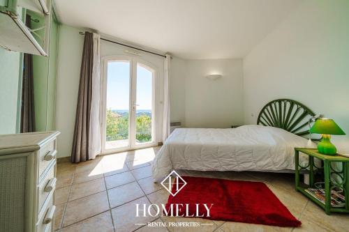 une chambre avec un lit et une grande fenêtre dans l'établissement Villa avec vue panoramique sur le golfe de St Tropez - Villa Bicotine, à Sainte-Maxime