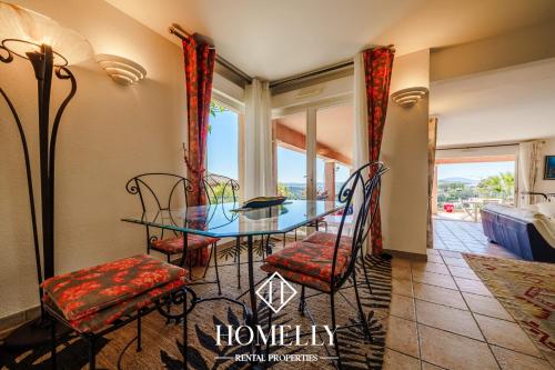 une salle à manger avec une table et des chaises en verre dans l'établissement Villa avec vue panoramique sur le golfe de St Tropez - Villa Bicotine, à Sainte-Maxime