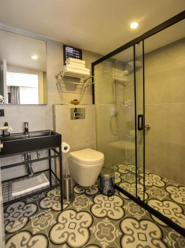 a bathroom with a toilet and a glass shower at Ağva Casa Rosa Bungalov Otel in Sile