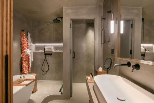a bathroom with a shower and a sink and a tub at Only YOU Hotel Málaga in Málaga