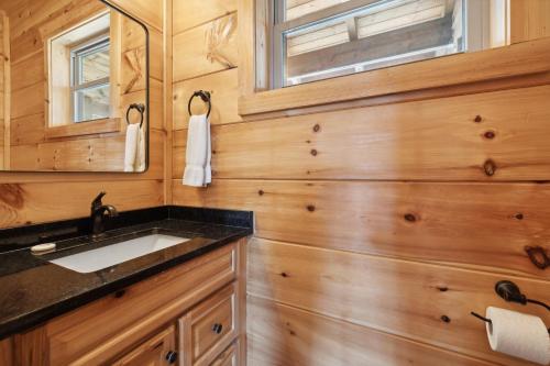 a bathroom with a sink and a mirror at Oakley Lodge: Luxury Cabin w/ MTN Views Indoor Pool • Hot Tub in Sevierville