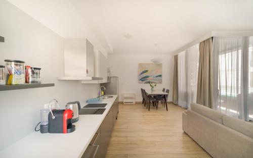 a kitchen and living room with a couch and a table at Amare Luxury Apartments in Budva