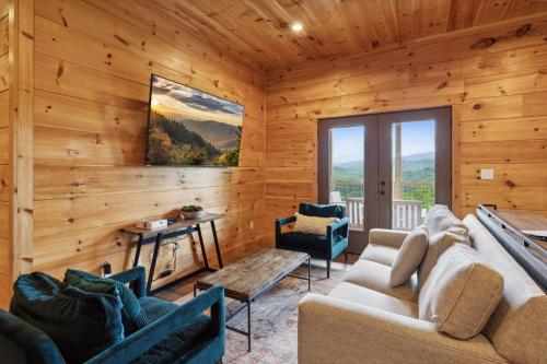 a living room with wooden walls and furniture in a cabin at Oakley Lodge: Luxury Cabin w/ MTN Views Indoor Pool • Hot Tub in Sevierville