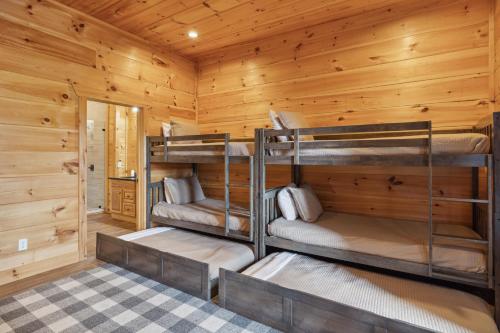 a log cabin with three bunk beds in it at Oakley Lodge: Luxury Cabin w/ MTN Views Indoor Pool • Hot Tub in Sevierville