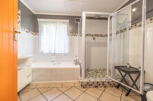 a bathroom with a shower and a tub and a sink at 1-on-Ross in Grahamstown