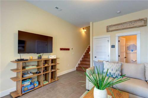 a living room with a couch and a flat screen tv at Spindrift by Seabrook Hospitality in Pacific Beach