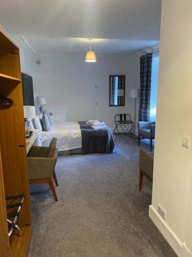 a bedroom with a bed and a desk and a chair at Ellwyn House in Edinburgh