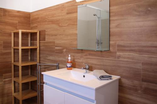 La salle de bains est pourvue d'un lavabo et d'un miroir. dans l'établissement Casas da Praia, à Manta Rota