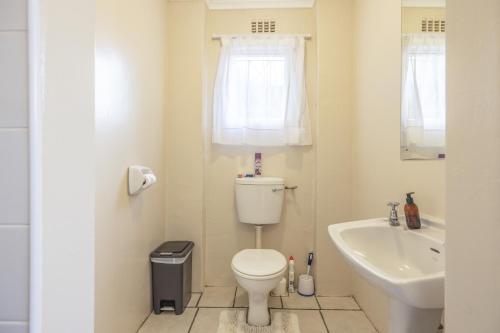 a small bathroom with a toilet and a sink at 1-on-Ross in Grahamstown