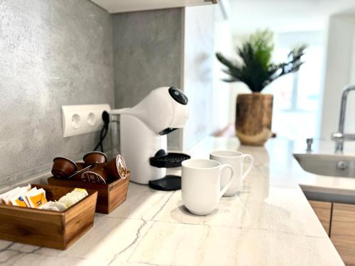 a kitchen counter with cups and a coffee maker at Apartamento Calas in Noja