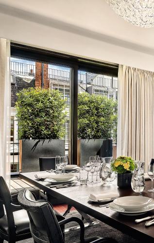 a dining room with a long table and chairs at Bvlgari Hotel London in London