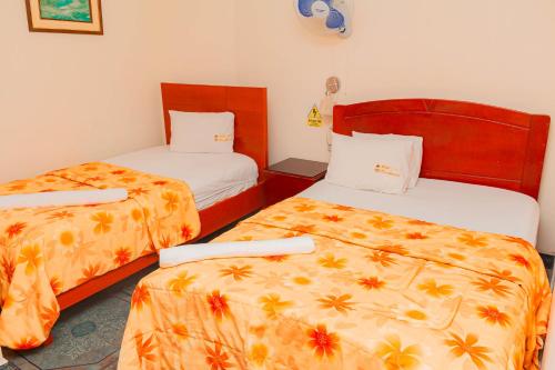 a hotel room with two beds with orange sheets at Hotel Presidencial in Chiclayo