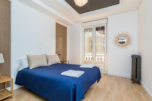 a bedroom with a blue bed and a window at BaruHaus Santo Domingo 2 in León