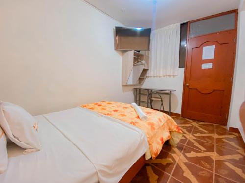 a room with a bed with an orange blanket on it at Hotel Presidencial in Chiclayo