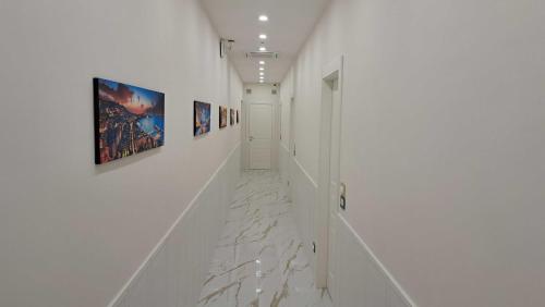 a hallway with white walls and paintings on the walls at AuRoom in Naples