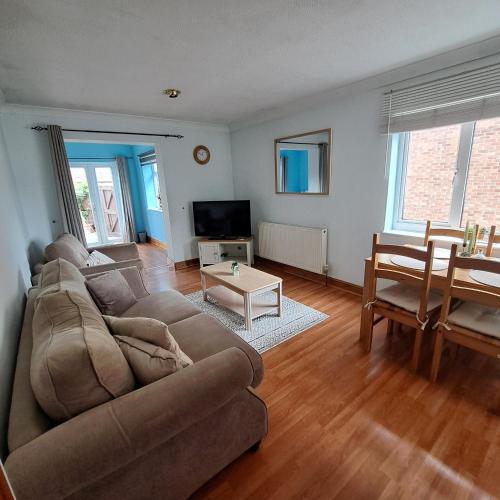 a living room with a couch and a table at Cute little 2 bed near Cambridge in Fenstanton