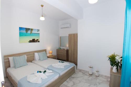 a bedroom with a bed with towels on it at Ammos Beach Apartment in Skaleta