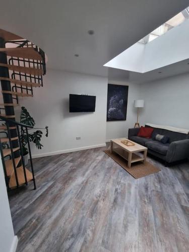 a living room with a couch and a table at New ground floor city centre apartment in Hull