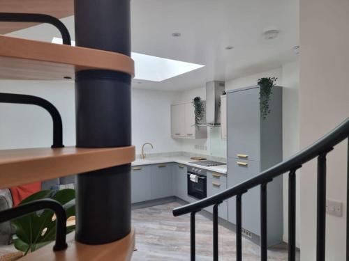 a kitchen with white walls and a black railing at New ground floor city centre apartment in Hull