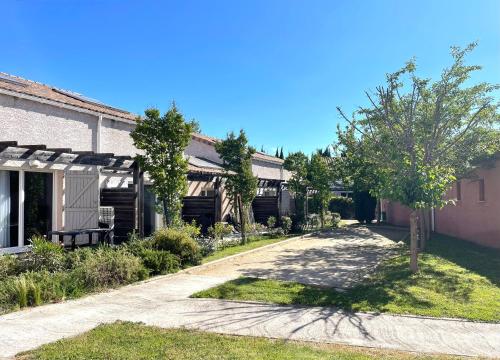 une maison avec un arbre et une allée dans l'établissement Terres de France - Le Domaine de Bacchus, à Saint-Christol