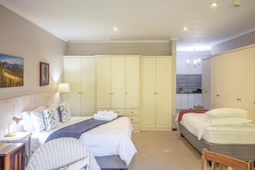 a bedroom with two beds and a table and chairs at 1-on-Ross in Grahamstown
