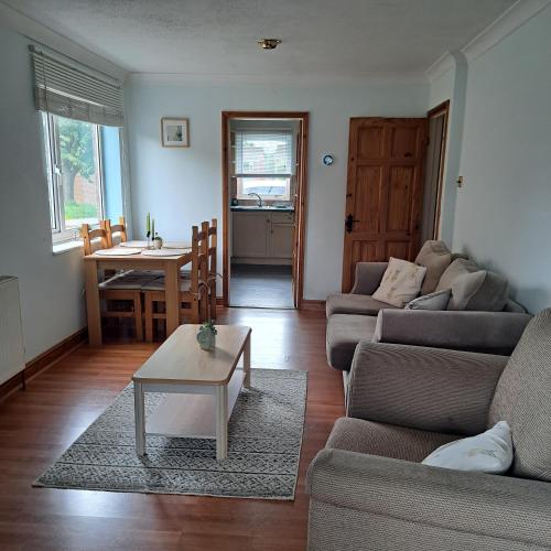 a living room with a couch and a table at Cute little 2 bed near Cambridge in Fenstanton