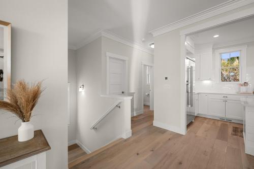 a white kitchen with white cabinets and a window at Solitude by Seabrook Hospitality in Pacific Beach